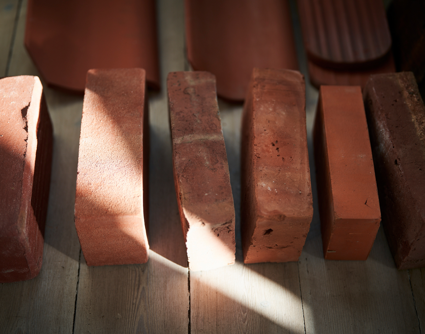 Ansicht auf Baumatialien, 4 Verschiedene rote Ziegelsteine sind nebeneinander Aufgestellt.